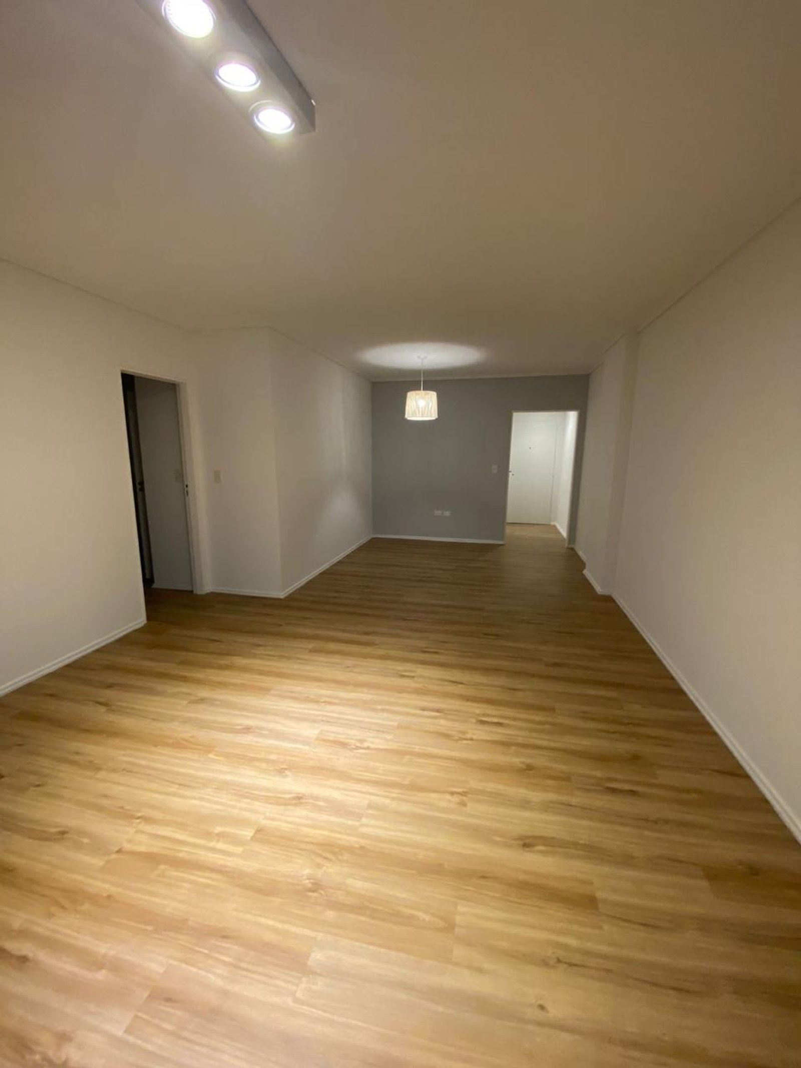 Sala de estar moderna e vazia com piso de madeira — projeto Zapiola, por Estudio NET Arquitectura, em Zapiola 2645